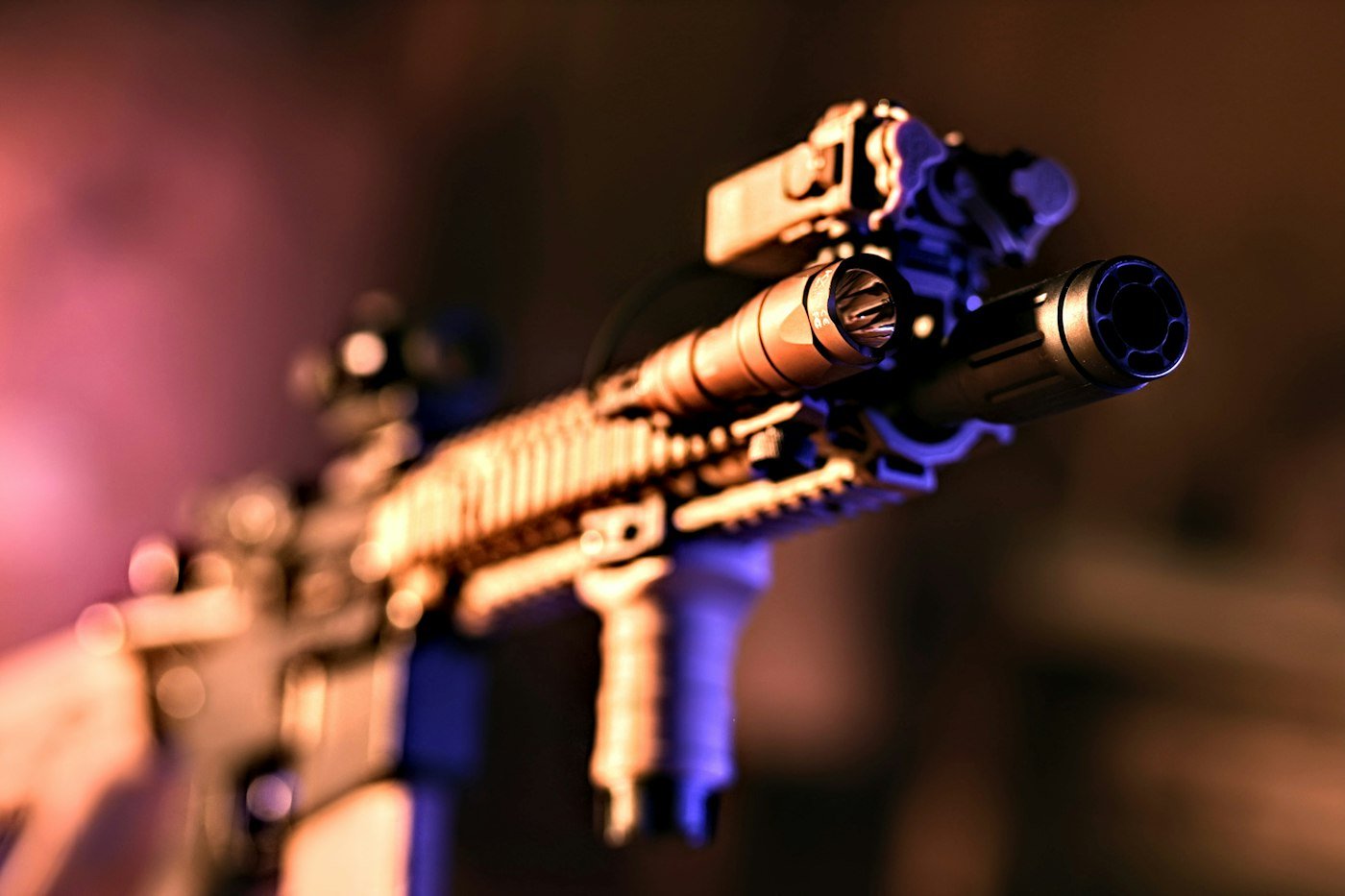 a close up of a rifle with a purple light in the background