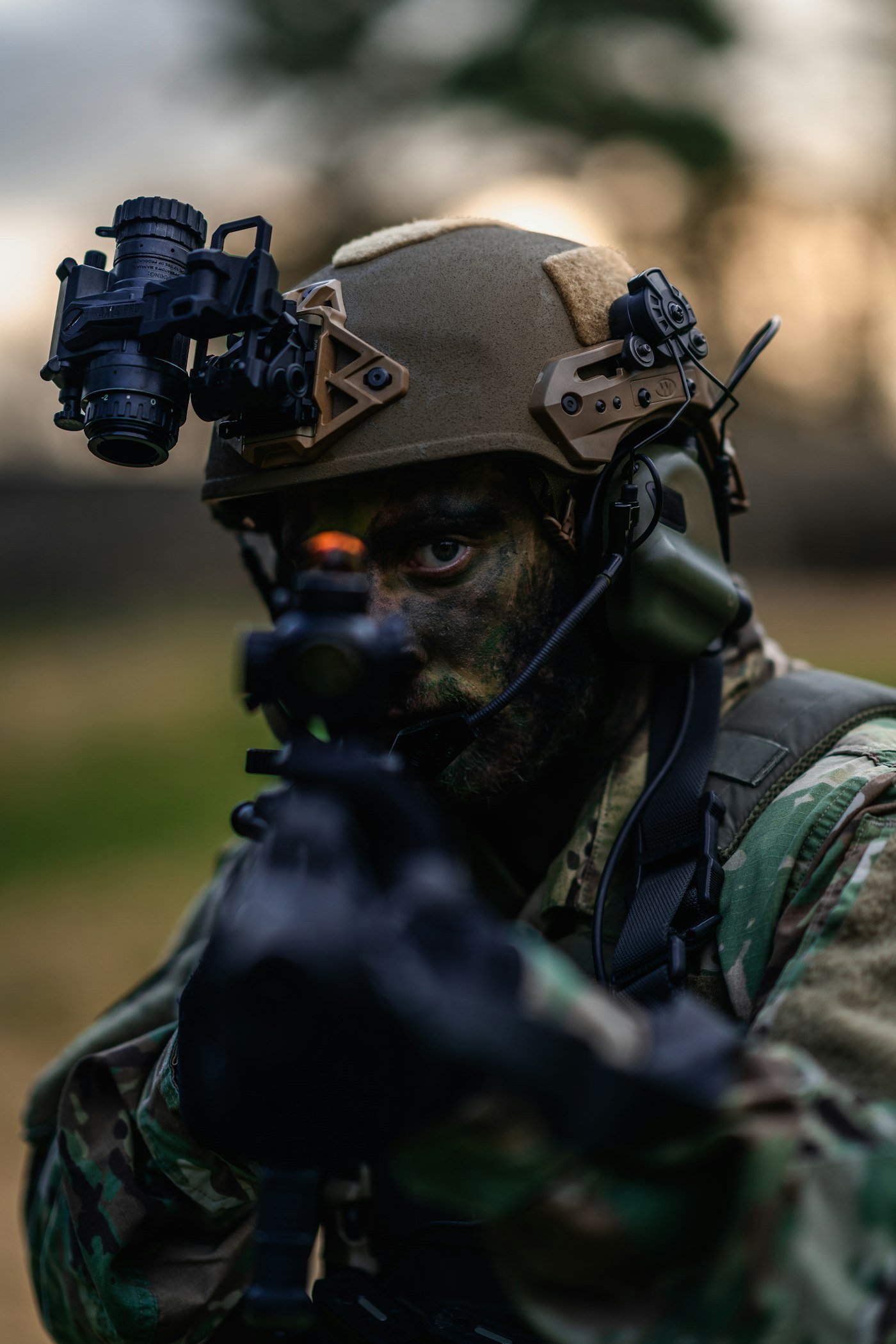 a man in camouflage holding a gun and wearing a helmet