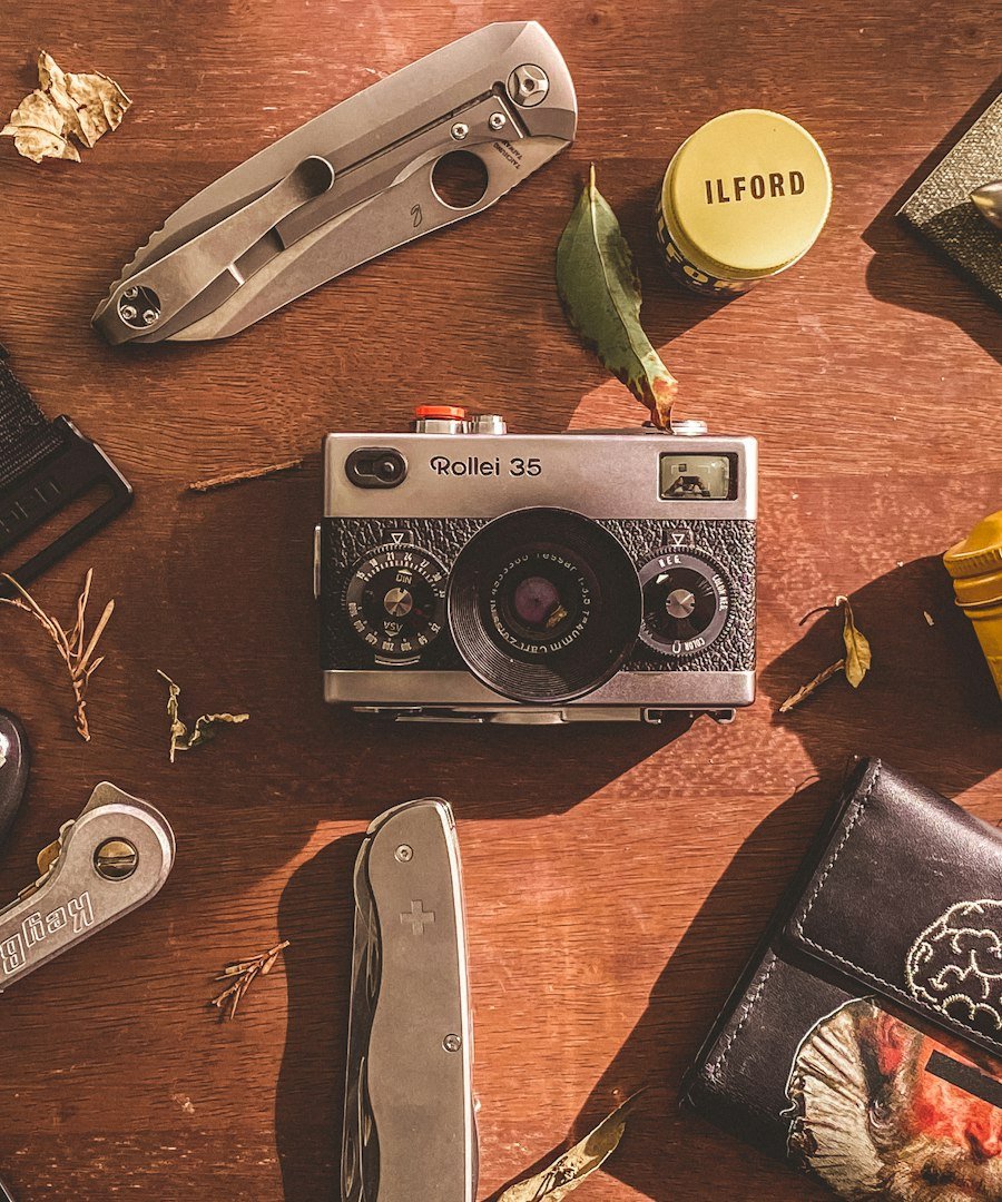 a wooden table topped with a camera and other items